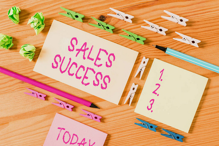 彩色衣夹放在木制地板中央的空矩形方形提醒纸条周围。有凹槽和槽的木头。办公用品,铅笔和钢笔。